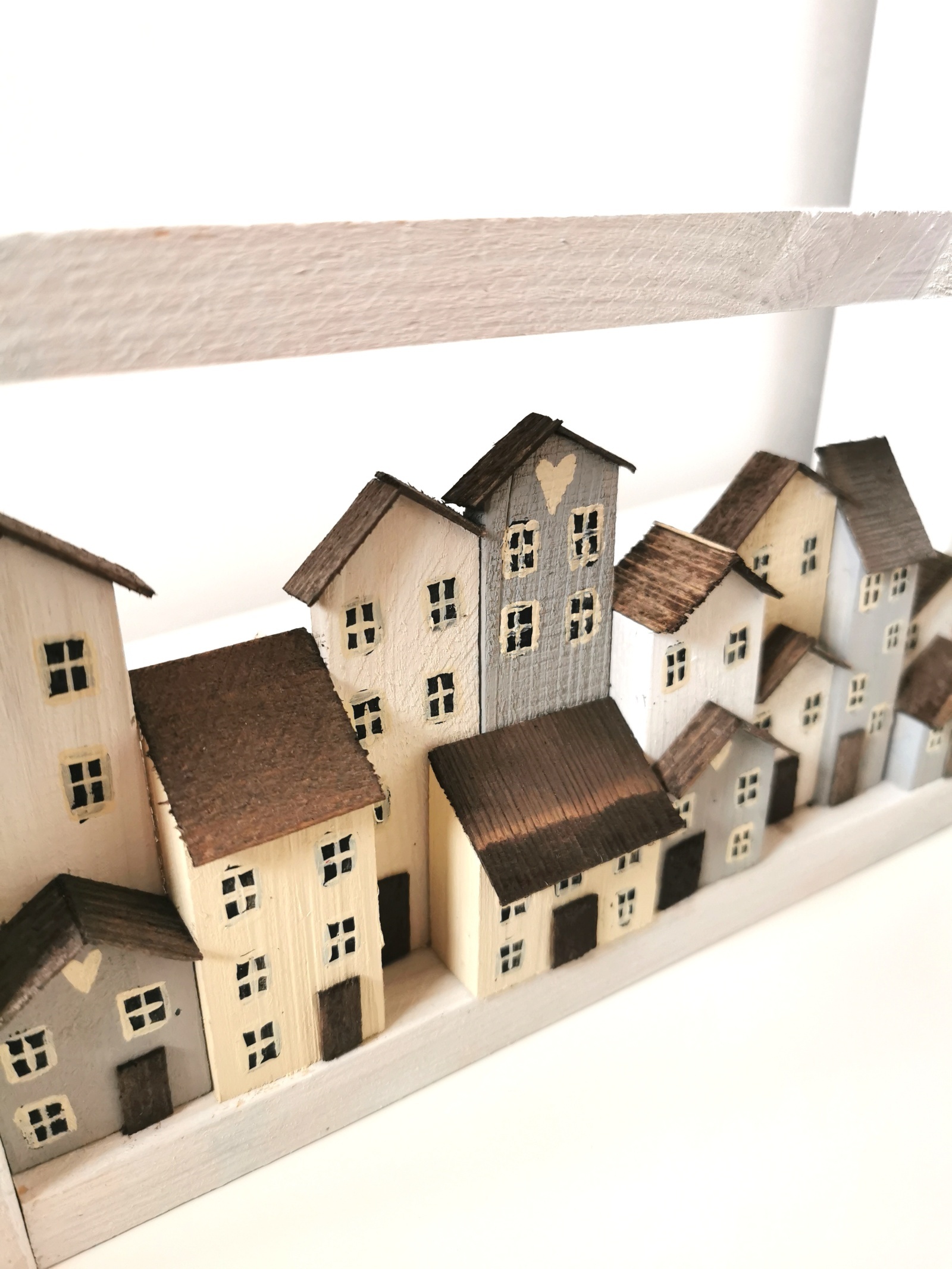 Dřevěný bílý obrázek se spoustou domečků