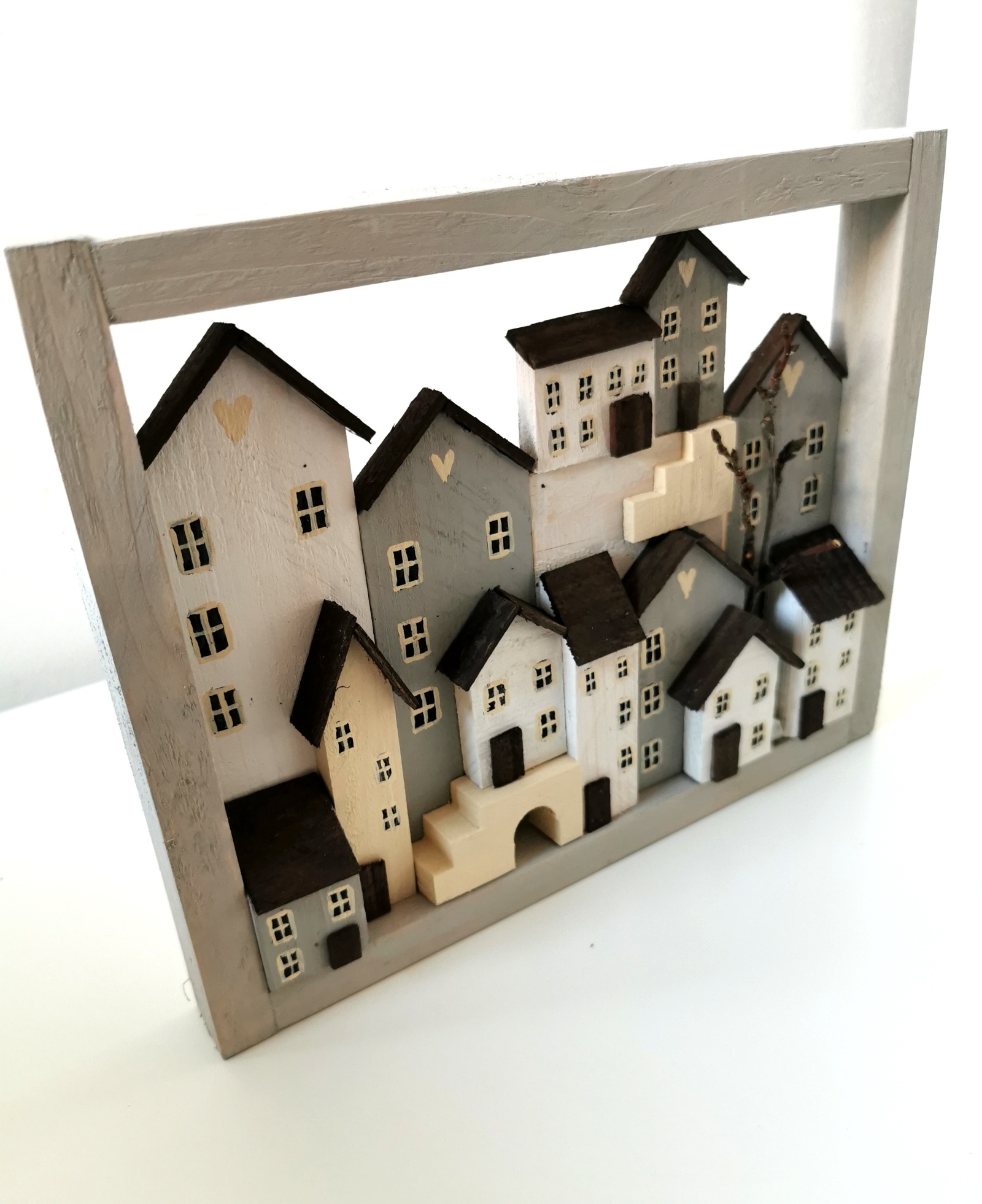 Dřevěný šedobílý obrázek plný domečků