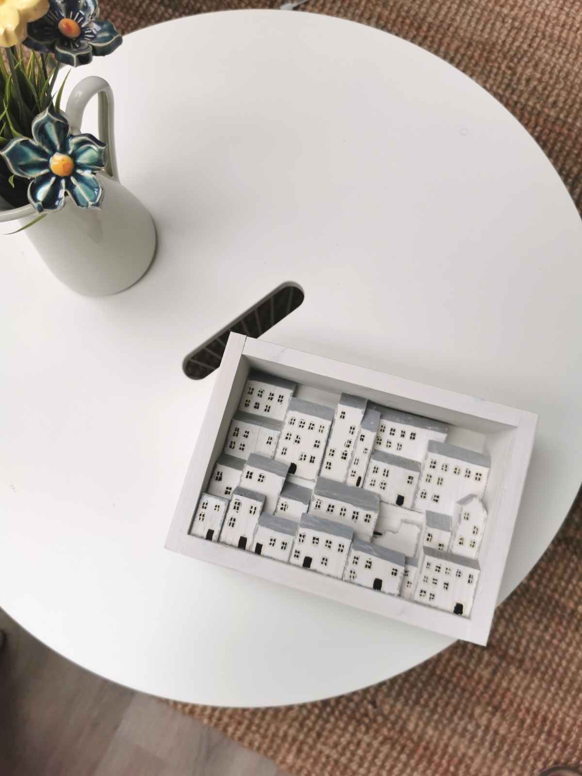 Dřevěný obrázek plný bílých domků s hlubokou perspektivou