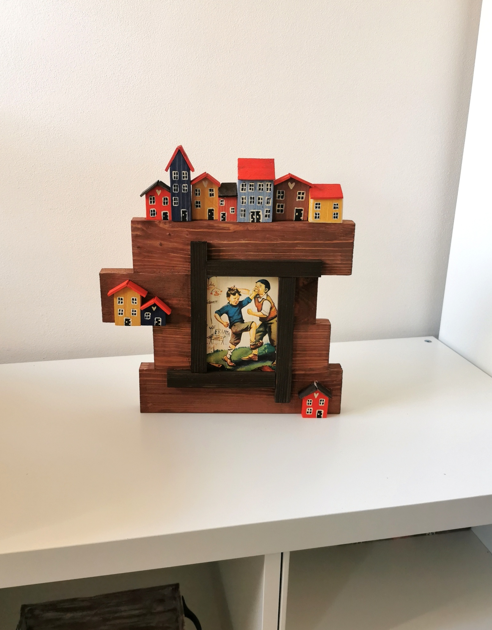 Dřevěný rámeček na fotografii s domečky