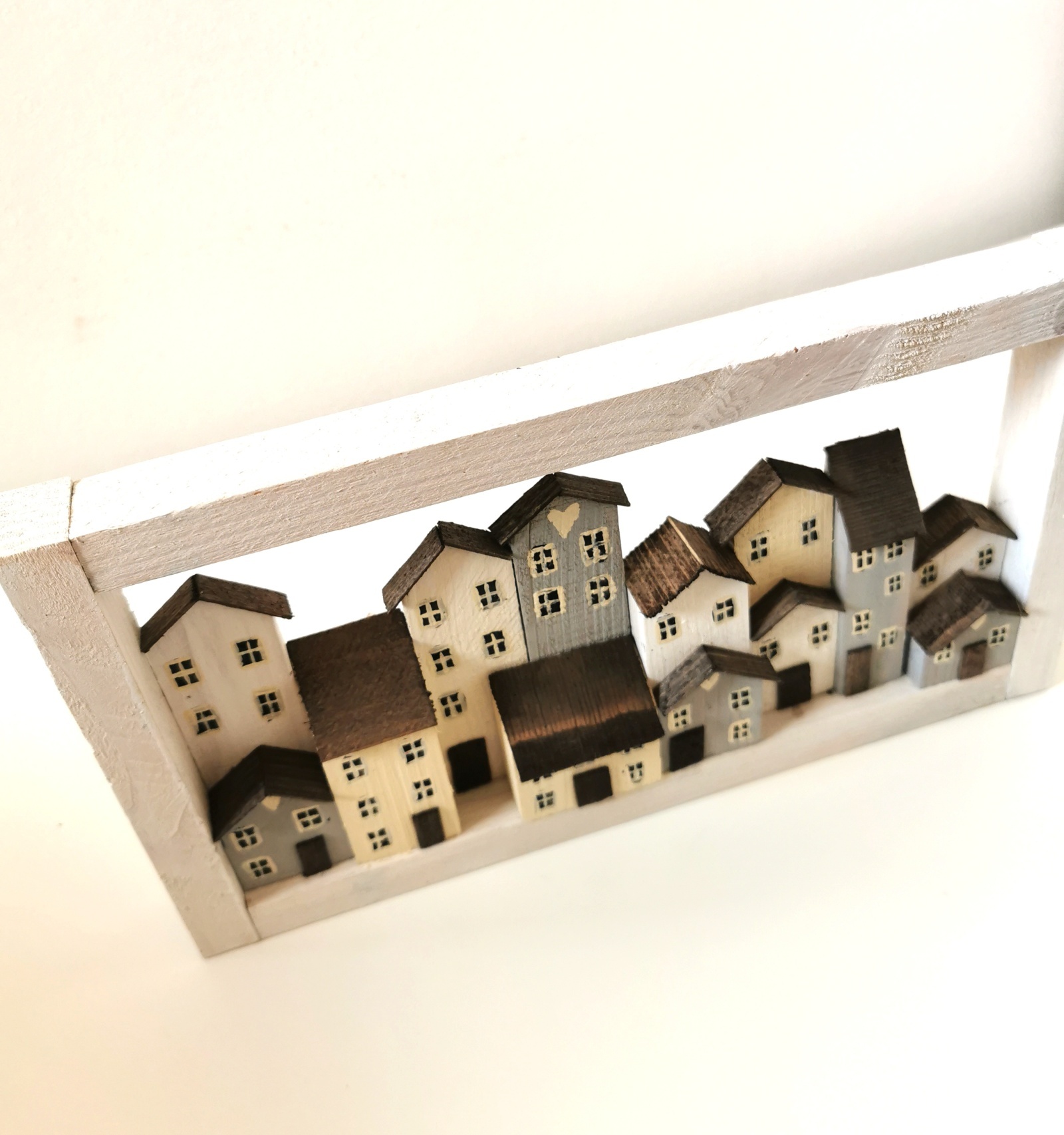 Dřevěný bílý obrázek se spoustou domečků