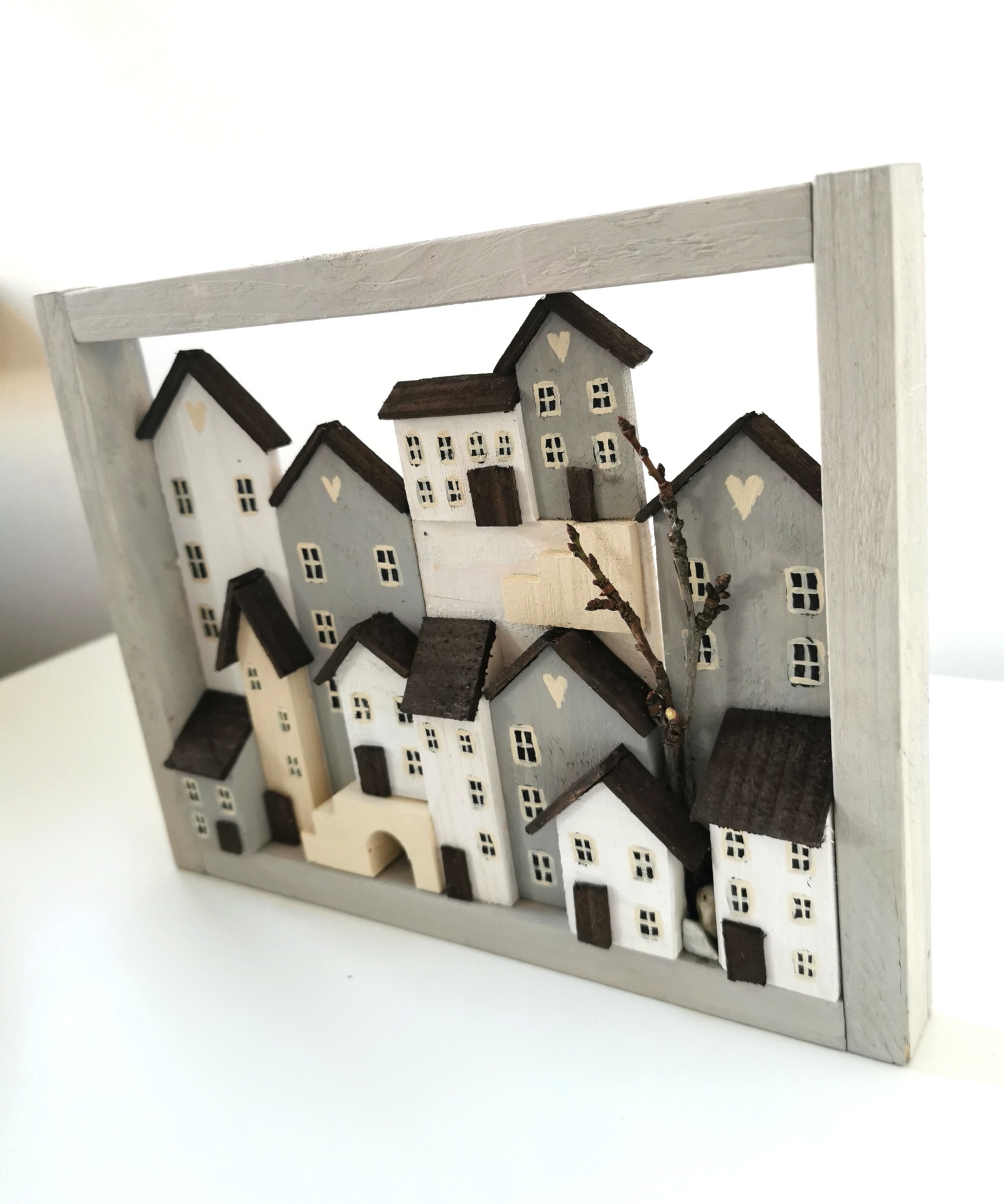 Dřevěný šedobílý obrázek plný domečků