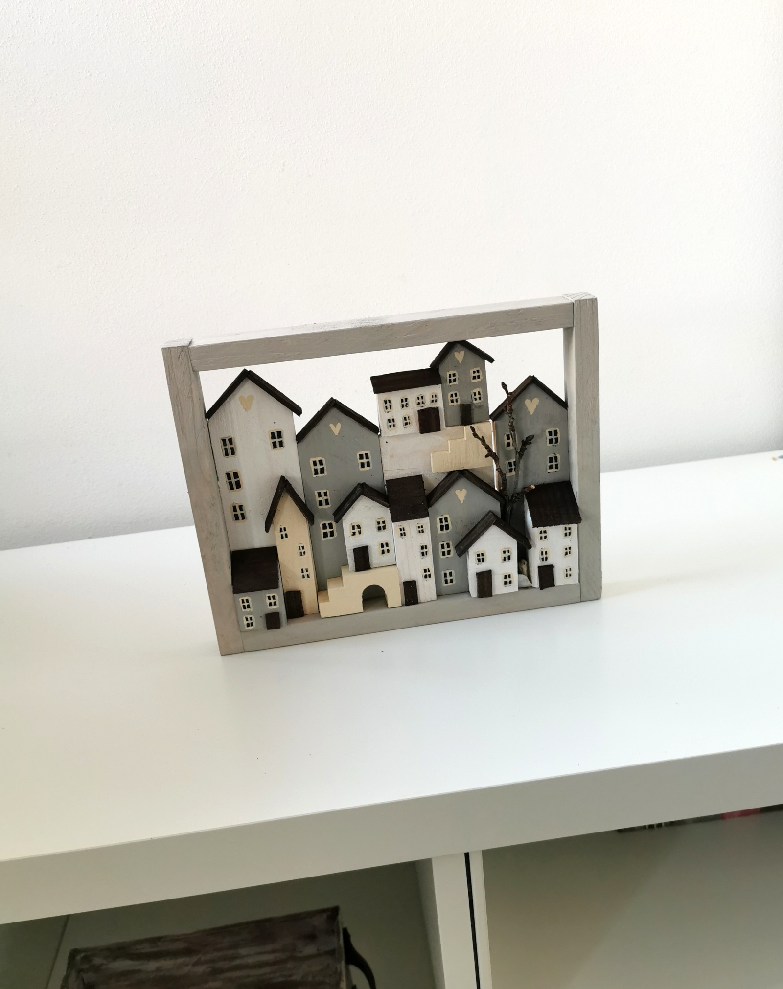 Dřevěný šedobílý obrázek plný domečků