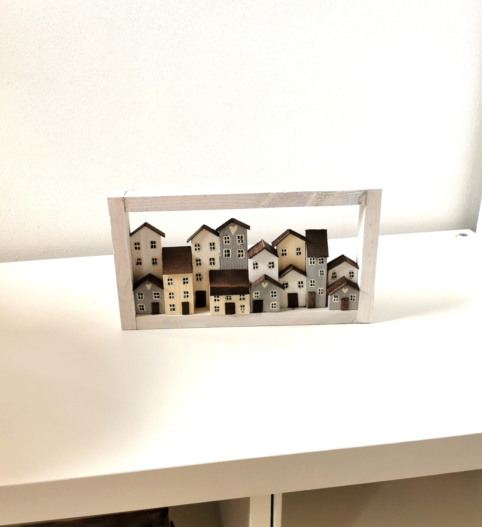Dřevěný bílý obrázek se spoustou domečků
